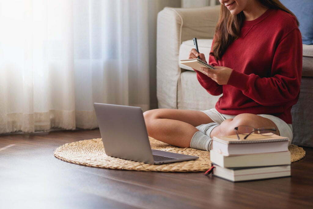 a woman sitting at a desk with a laptop and books