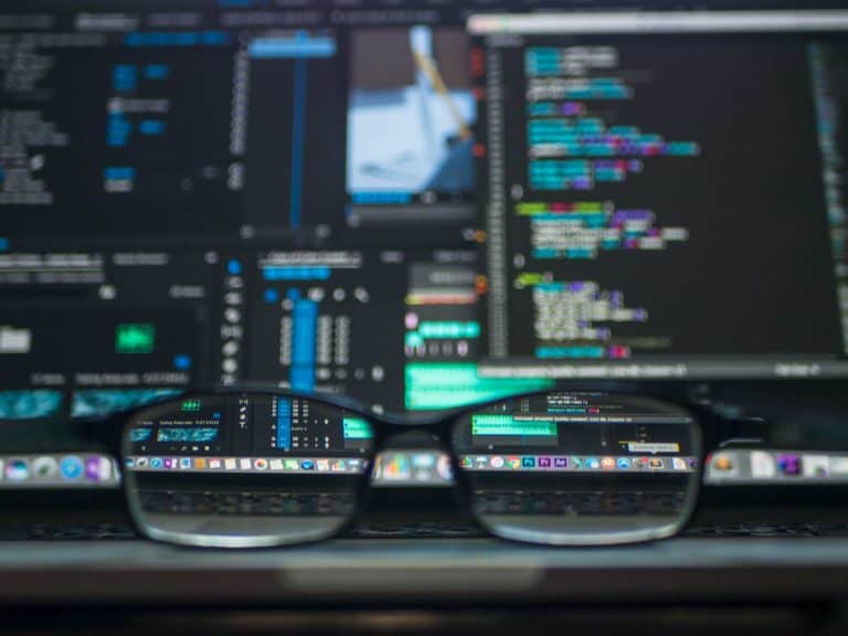 Black farmed eyeglasses in front of laptop computer