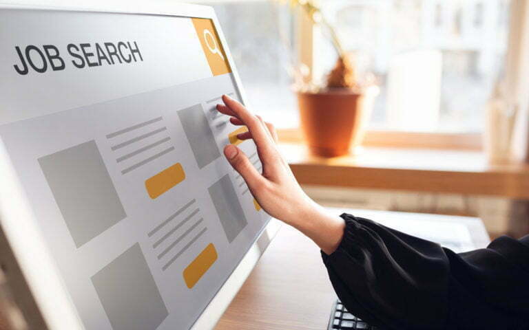 Female hand touching screen while looking for a job