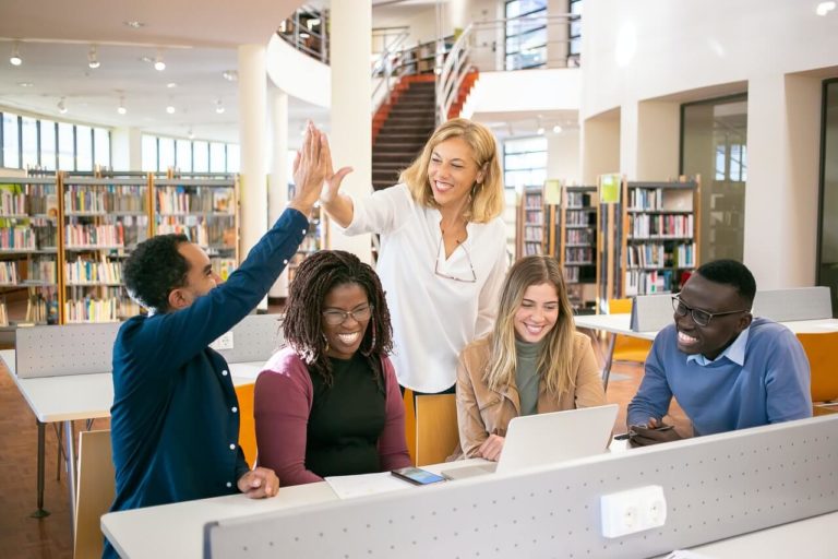 a person standing next to a group of people in a library
