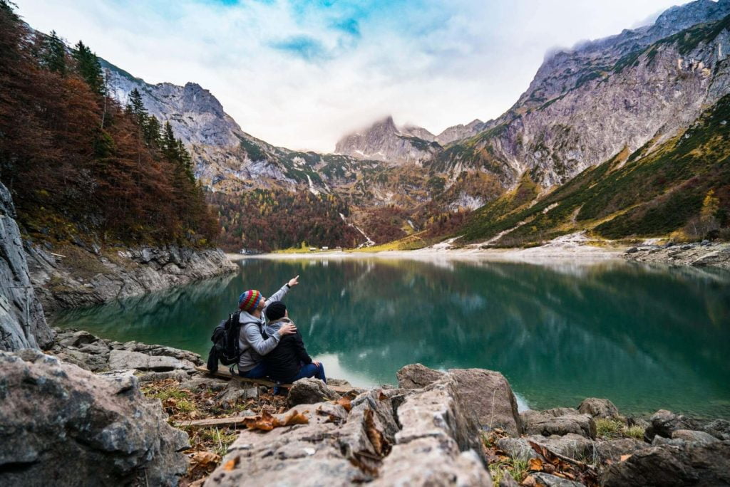 a person sitting on a rock near a lake