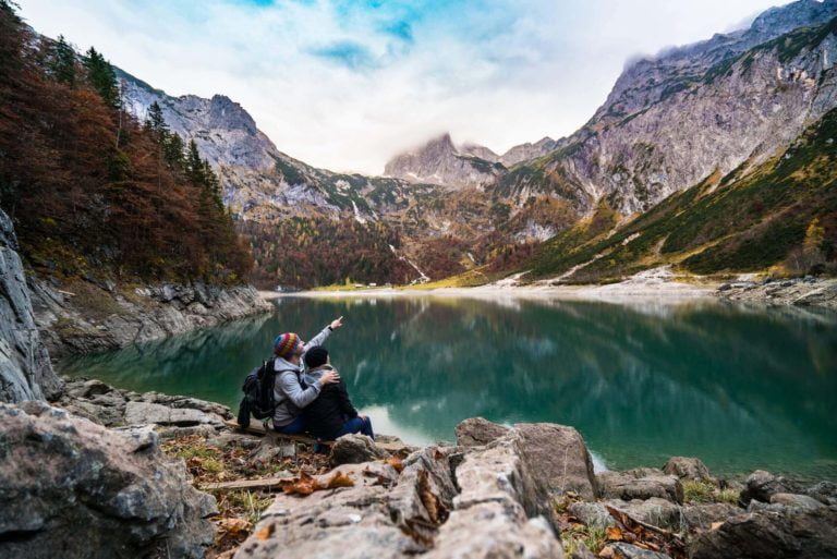 a person sitting on a rock near a lake