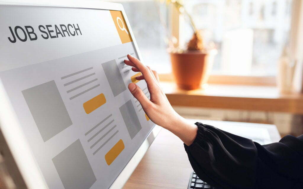 Female hand touching screen while looking for a job