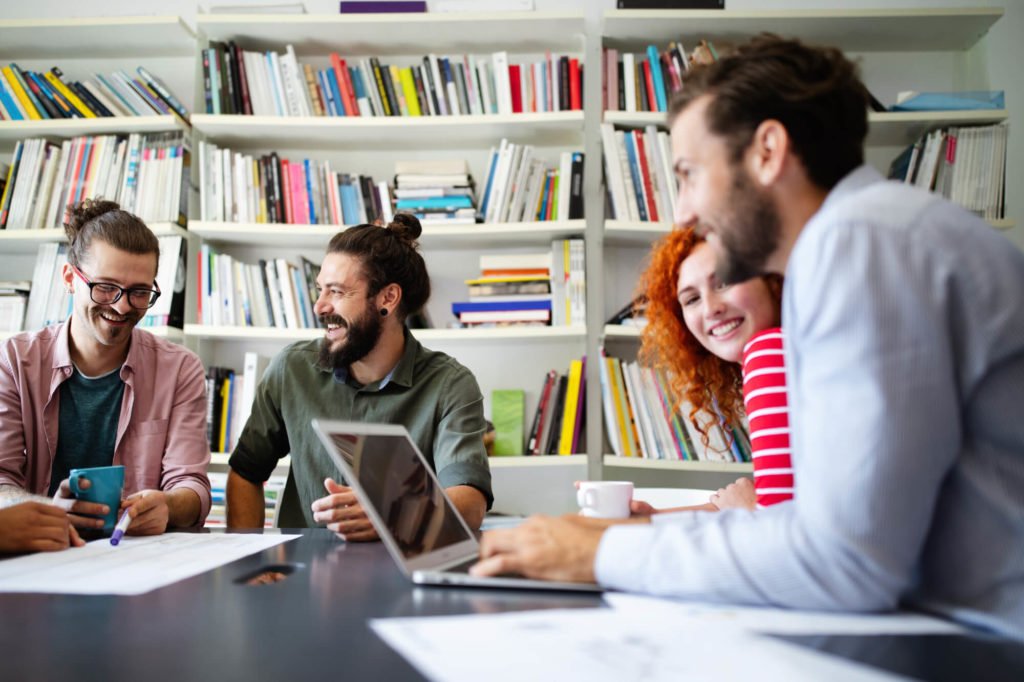 a group of people looking at a laptop