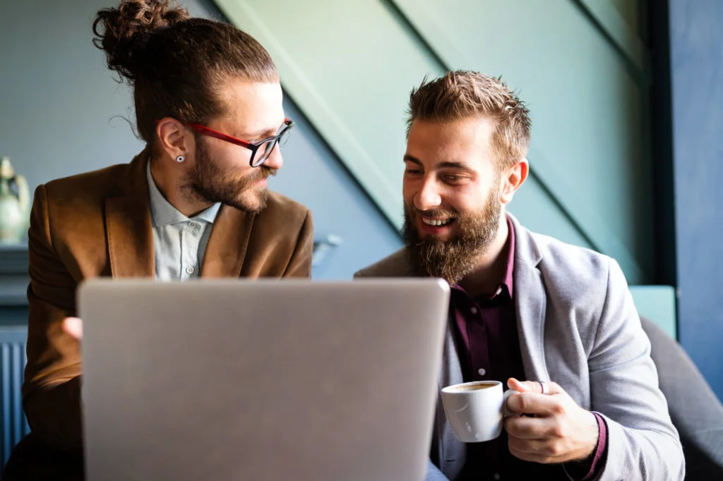a group of men looking at a laptop